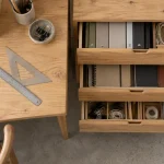 Meuble a tiroir en bois près du bureau, tiroirs ouverts et matériel d’atelier